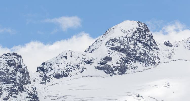 Pics montagneux enneigés sous un ciel d'un bleu éclatant.