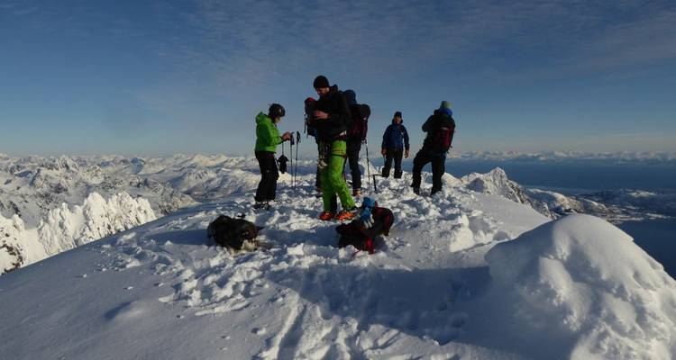 Gruppe von Menschen auf einem schneebedeckten Berggipfel.