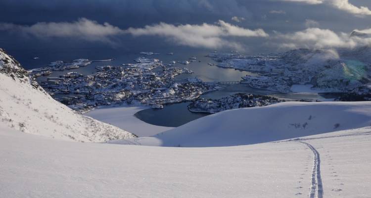 Schneelandschaft mit Blick auf eine Stadt und einen Hafen.