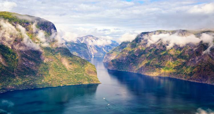 Luftaufnahme eines sich windenden Fjords unter einem teilweise bewölkten Himmel.
