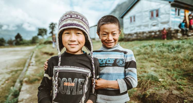 Twee glimlachende jongens die samen staan, warm gekleed.