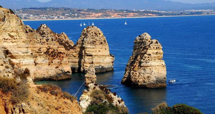 Los icónicos acantilados de Ponta da Piedade emergiendo de aguas azul profundo con veleros cerca