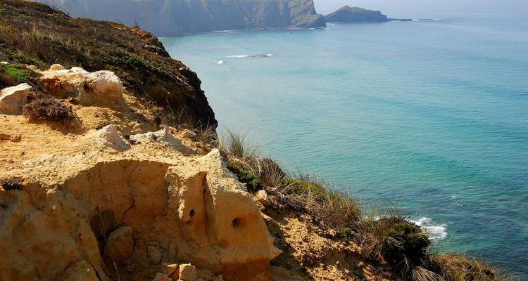 Mirador de costa rocosa con vistas al mar turquesa tranquilo y a los cabos lejanos