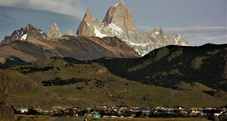 Le mont Fitz Roy dominant une petite ville avec un horizon lointain.