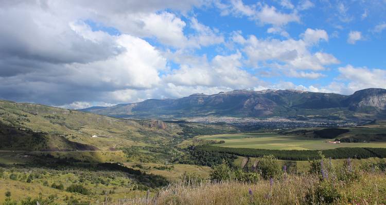 Ruime vallei met bergen en bewolkte hemel.