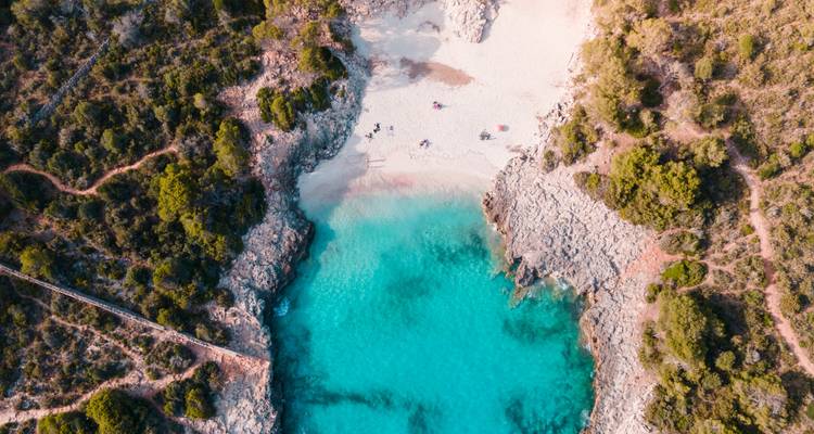 Vista aérea de una pequeña playa apartada con una laguna turquesa.