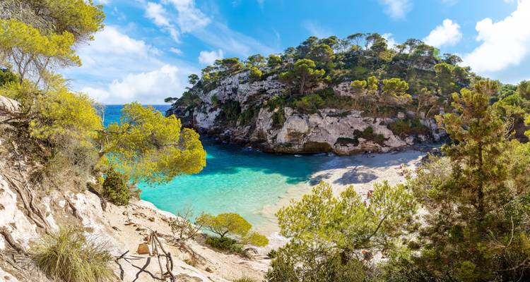 Cala prístina con aguas turquesas y acantilados circundantes.