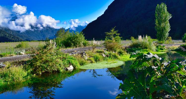 Uitzicht over de rivier met helder water dat de lucht weerkaatst.