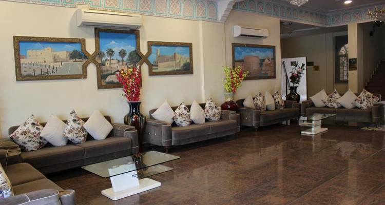 Vestíbulo de hotel con asientos cómodos y pinturas decorativas.