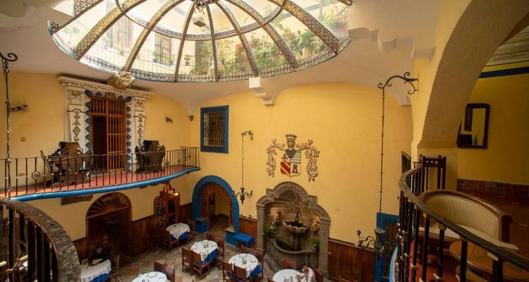 Essbereich in einem historischen Gebäude mit einer verzierten Decke.