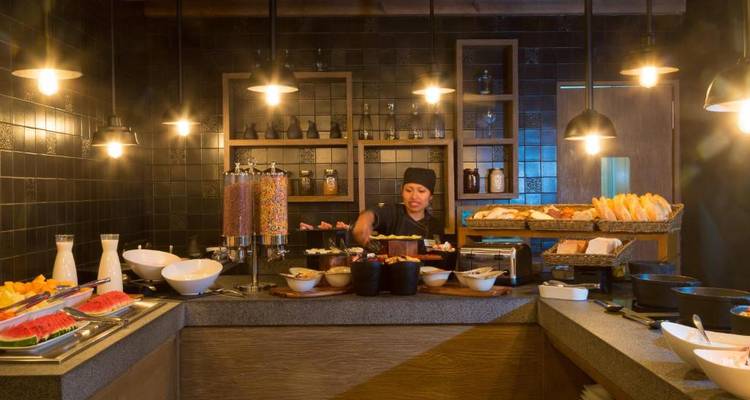 Büfettfrühstück mit verschiedenen Speisen in gedämpfter Beleuchtung.