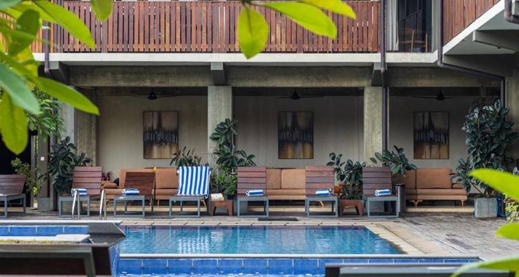 Zithoek bij het zwembad met handdoeken op ligstoelen.