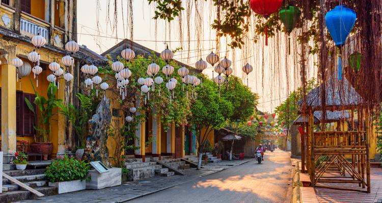 Straße in Hoi An, geschmückt mit bunten Laternen bei Sonnenuntergang.