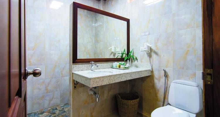 Moderne badkamer met een grote spiegel en badkamervoorzieningen.