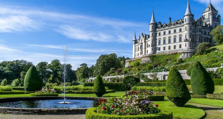 Scottish castle with manicured gardens and a fountain.