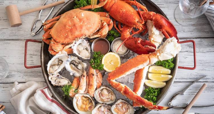 Seafood platter with various shellfish on ice.