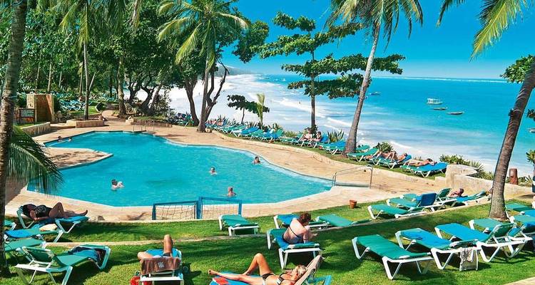 Resort pool area with sun loungers and ocean view.