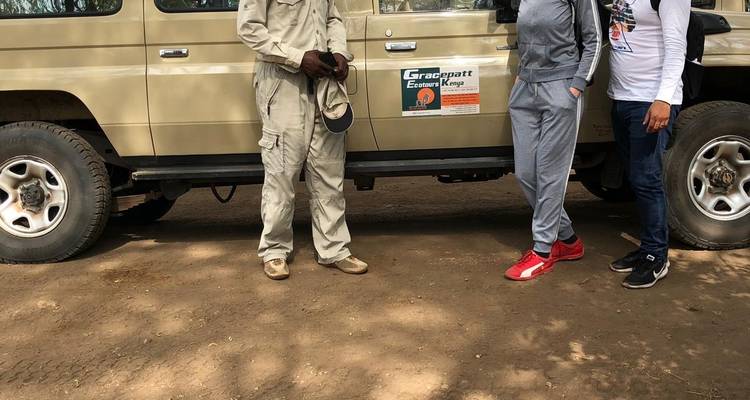 People standing beside a safari vehicle.