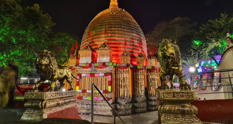 Kamakhya Tempel 's nachts met levendige verlichting en leeuwenbeelden.