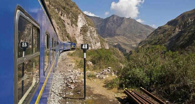 Zug, der durch eine malerische Berglandschaft fährt.