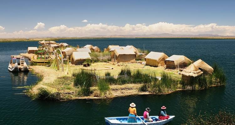 Floating islands with people on a boat on a lake.