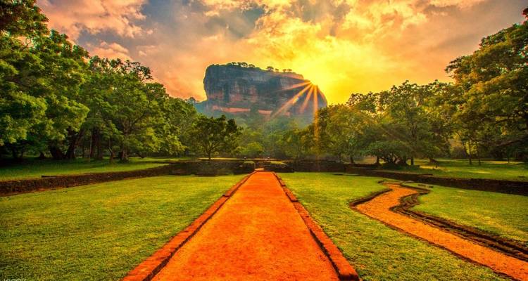 Sonnenuntergangsblick auf die Felsenfestung Sigiriya, umgeben von Gärten.