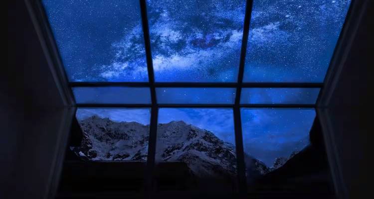 Nachtelijke hemel met sterren bekeken door een raam.