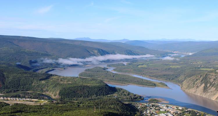 Rivière serpentant à travers un paysage de vallée verdoyante luxuriante.