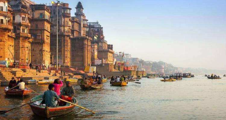 Boote auf dem Ganges mit historischen Ghats im Hintergrund.