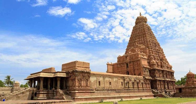 Un grand temple avec des sculptures détaillées contre un ciel bleu.