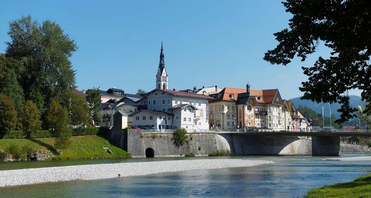 Une ville pittoresque au bord de la rivière avec un pont et une église.