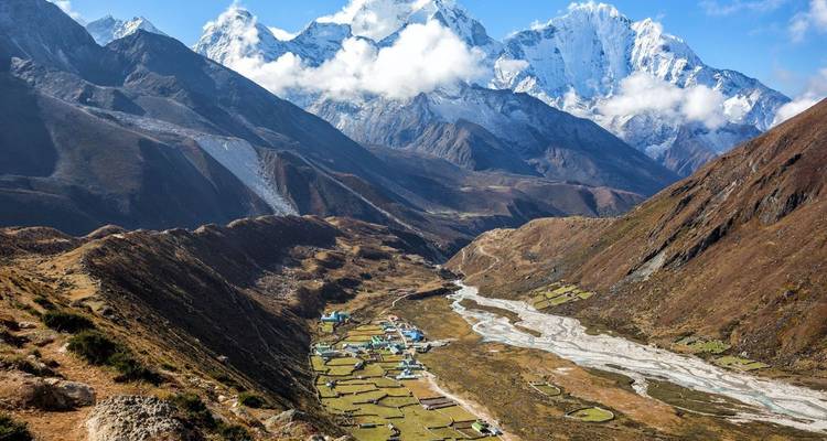 Vallei met een dorp omringd door torenhoge bergen.