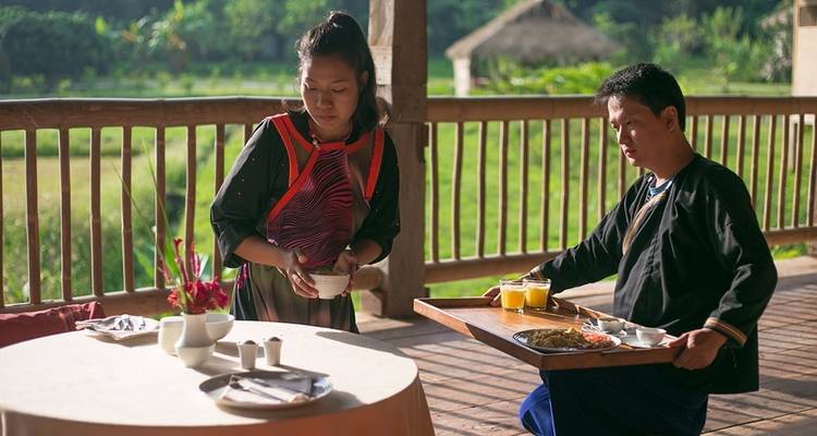 Traditioneel gekleed stel dat eten en drinken serveert aan tafel.