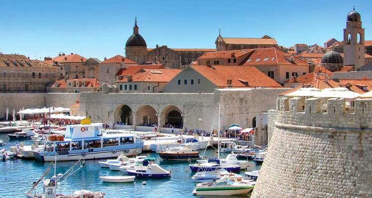 Malerische Aussicht auf Boote, die in einem historischen Hafen mit Steinmauern anlegen.