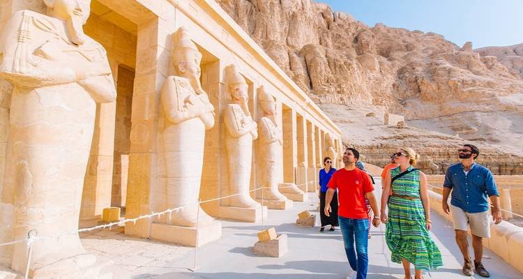 Touristen, die vor Tempelverzierungen gehen.