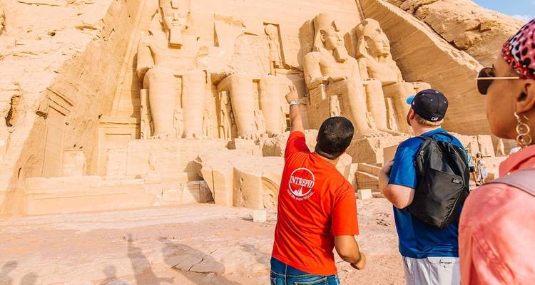 **Tour guide explaining Abu Simbel to tourists:**
---
**English:**
"Welcome everyone to Abu Simbel, one of Egypt's most magnificent archaeological sites! These incredible temples were carved directly into the rock face over 3,000 years ago by Pharaoh Ramesses II. The four colossal statues you see here are each 20 meters tall and represent the pharaoh himself. What's truly remarkable is that this entire complex was carefully dismantled and relocated in the 1960s to save it from flooding when th
