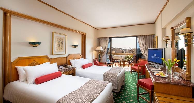 Hotel room with twin beds and a balcony view.