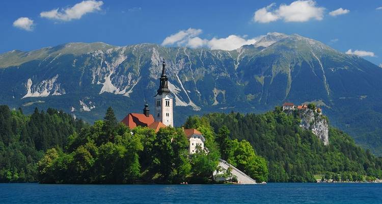 Une église pittoresque sur une île entourée d'un lac et de montagnes.