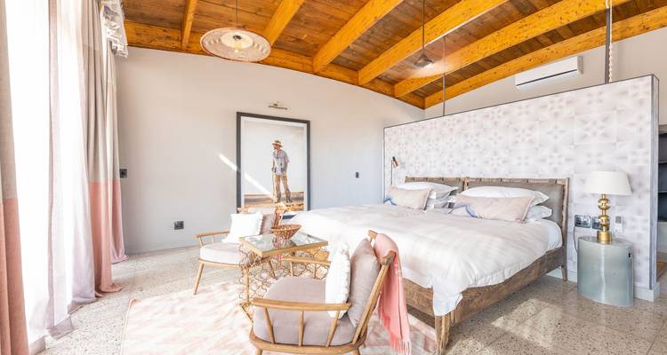 Bright, stylish bedroom interior of luxury desert villa with wooden ceiling and modern decor