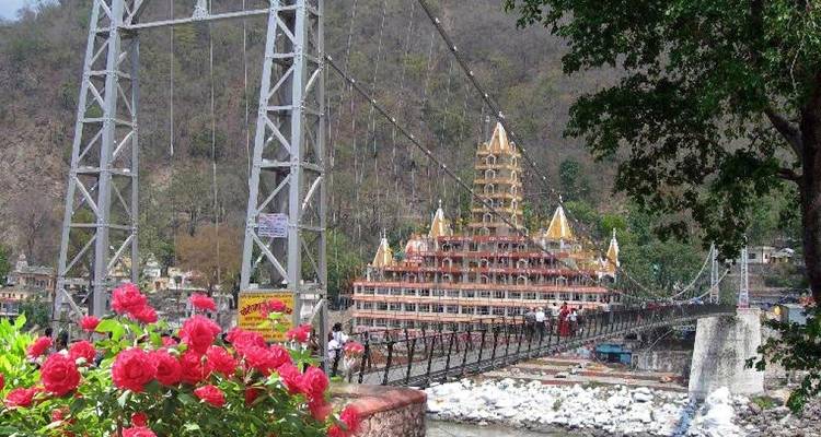 Een schilderachtig uitzicht op een hangbrug met een tempel op de achtergrond.