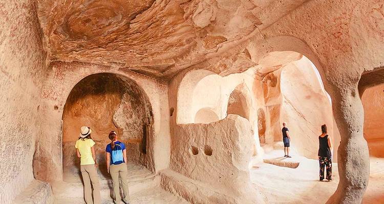 Touristen, die das Innere einer historischen Höhlenwohnung erkunden.
