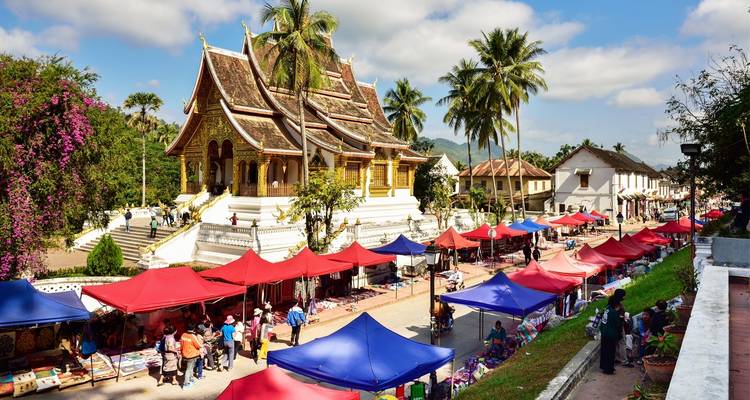 Marktstraße mit bunten Zelten und traditioneller Architektur.