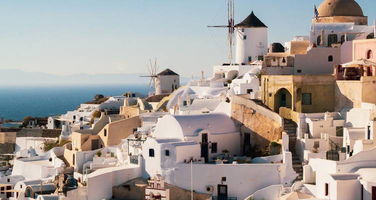 Paysage ensoleillé de Santorin avec des bâtiments blancs.