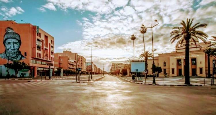 Zonnige straat met muurschilderingen en moderne gebouwen.