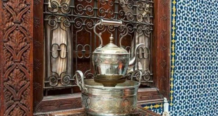 Decoratieve zilveren theepot op een standaard voor sierlijke tegels.