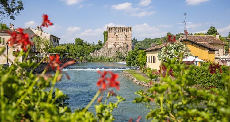 Malerische Flussszene mit antiken Ruinen und leuchtenden Blumen
