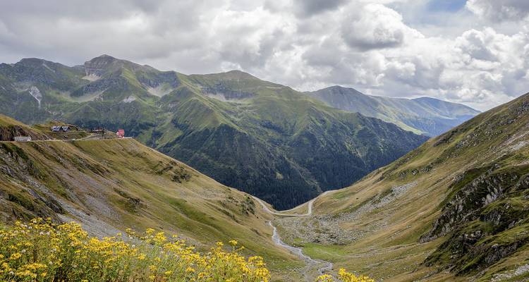 Vallée de montagne pittoresque avec route sinueuse et collines.