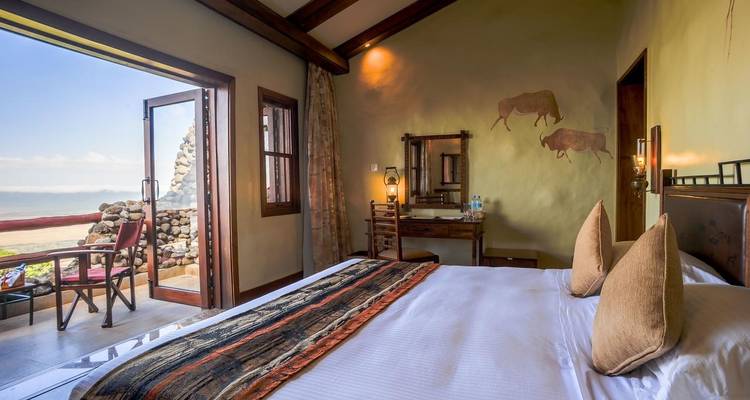 Schlafzimmer mit malerischem Ausblick durch eine offene Tür, Dekoration im afrikanischen Stil.