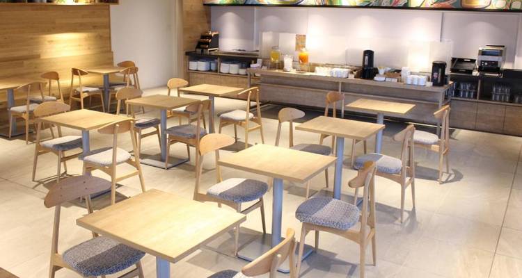 Área de comedor con mesas y sillas minimalistas.