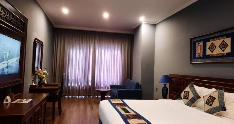 Hotelzimmer mit Doppelbett und Bergblick.